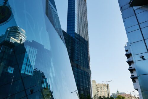 Prédios comerciais modernos refletem fachada de vidro, ilustrando mercado de FIIs e dividendos imobiliários.
