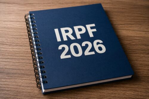Caderno com IRPF 2026 sobre mesa, representando restituição do Imposto de Renda e calendário de pagamentos.