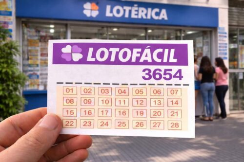Aposta na Lotofácil 3654 sendo feita em uma lotérica, com uma pessoa segurando o bilhete frente à fachada da lotérica.