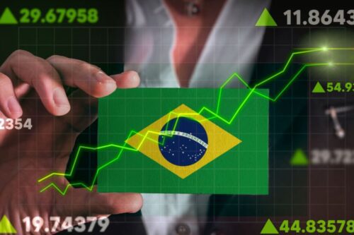 Uma composição digital mostrando uma mão segurando um cartão com a bandeira do Brasil.