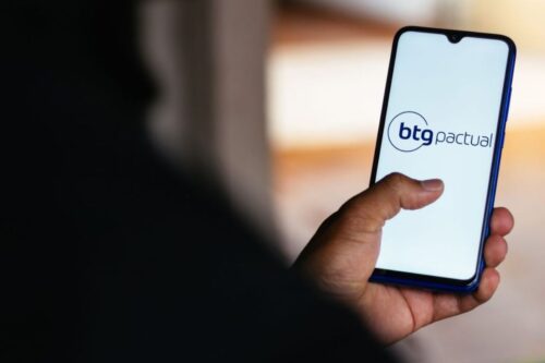 Celular aberto, com a logo do BTG Pactual.