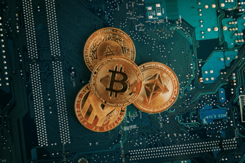 Closeup das moedas Bitcoin, Ethereum, Litecoin e Cardano na placa de circuito eletrônico.