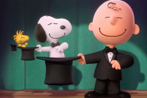 Uma animação digital em 3D dos personagens de Peanuts em um palco com cortina verde. À direita, Charlie Brown sorri vestindo um terno preto com gravata borboleta, segurando uma cartola preta de mágico. De dentro da cartola surge o cão Snoopy, também de gravata borboleta, que por sua vez segura uma cartola menor de onde sai o passarinho Woodstock. Todos estão sorrindo com os olhos fechados.