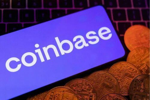 Close-up de um smartphone exibindo o logotipo da Coinbase em uma tela azul vibrante.