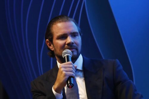 Fotografia de Daniel Vorcaro em plano médio, falando ao microfone durante um evento.