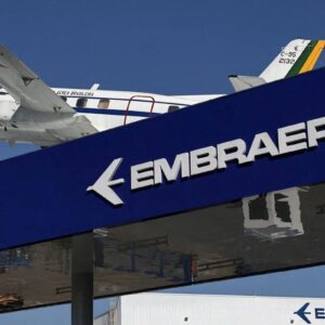Placa azul com o logotipo da Embraer em letras brancas em destaque.
