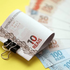 Vista aproximada de notas de dinheiro em reais brasileiros em grande quantidade em amarelo. Pilha de moeda real do Brasil