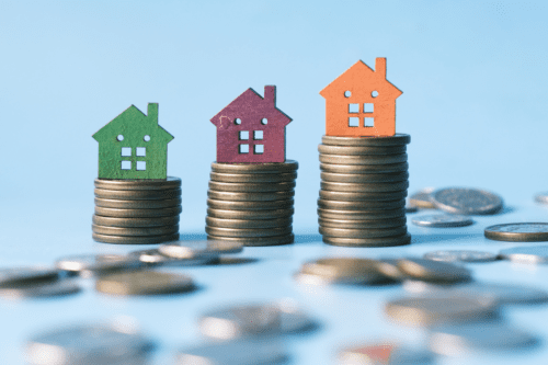 pilha de moedas e casa na mesa, o conceito de fundos imobiliários.