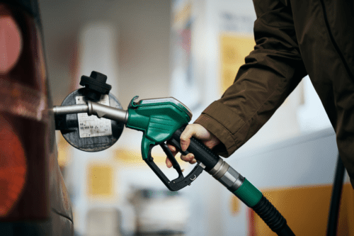 Close-up de uma mulher enchendo o tanque de combustível do carro na bomba de gasolina.