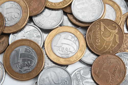 Moeda de R$ 1 real, sobreposta à moedas de outros valores.