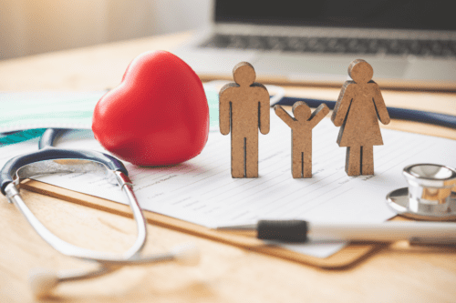 Conceito de seguro médico com família e estetoscópio na mesa de madeira.