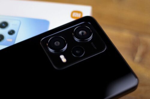 Close-up da parte traseira de um smartphone Xiaomi na cor preta brilhante, destacando o módulo de câmeras triplas.