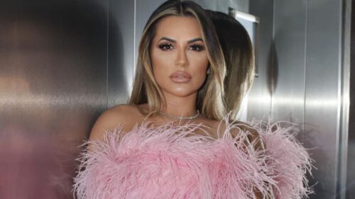 Influenciadora Deolane Bezerra posa com vestido rosa em foto, representando antes de ser presa em investigação sobre PCC.