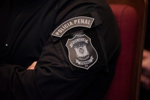 Agente da Polícia Penal do RS, representando anúncio de edital com 213 vagas e salários de até R$ 9,7 mil.
