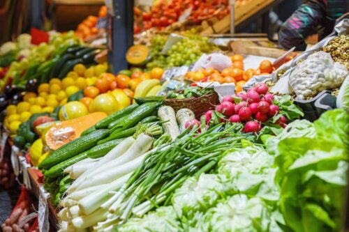 IPCA abril 2026 mostra alta nos preços de alimentos em feira com frutas, verduras e legumes expostos.