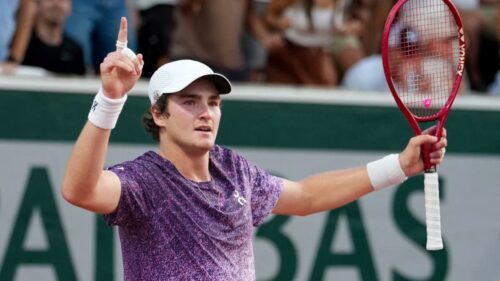 João Fonseca comemora ponto, representando partida em Roland Garros antes de duelo contra Novak Djokovic.