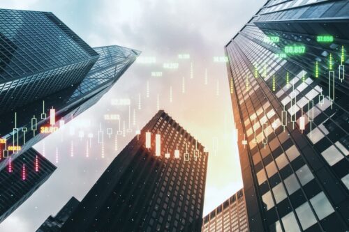 Prédios corporativos com gráficos financeiros digitais representam o avanço do mercado de capitais.