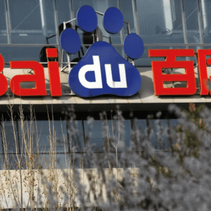 Fachada de um edifício com o logotipo da Baidu em destaque. O nome "Baidu" está escrito com as letras "Bai" e os caracteres chineses "百度" em vermelho, enquanto as letras "du" estão em branco, inseridas dentro de uma grande pegada de animal azul. Em primeiro plano, a imagem mostra galhos de árvores e flores levemente desfocadas.