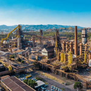 Vista aérea de uma siderúrgica industrial com fornos e tubulações, da CSN.