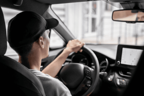 Um jovem dirigindo um carro.