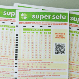 Três volantes oficiais de papel da loteria "Super Sete", da Caixa Econômica Federal, dispostos lado a lado sobre uma superfície clara. Os bilhetes possuem detalhes em verde e trazem a tabela principal dividida em 7 colunas numeradas de 1 a 7, com opções de números de 0 a 9 para marcar em cada uma delas. No canto superior esquerdo de cada volante, há o logotipo de um trevo de quatro folhas branco dentro de um quadrado verde, seguido pelo nome do jogo escrito em letras minúsculas brancas. Do lado direito da tabela de números, há um código QR em preto e branco.