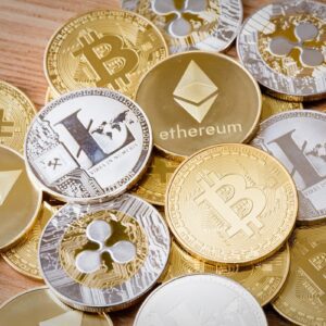Moedas físicas de Bitcoin, Ethereum, Litecoin e Ripple espalhadas sobre superfície de madeira.