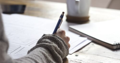 Concursos com inscrições abertas: candidata estuda com notebook e cadernos para provas de concurso público