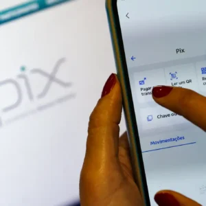 PIX novas regras 2026: mão segurando smartphone com aplicativo bancário de PIX