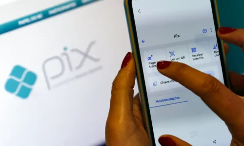 PIX novas regras 2026: mão segurando smartphone com aplicativo bancário de PIX