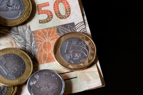Dinheiro real brasileiro e moedas em um fundo preto