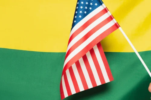 Bandeira dos EUA sobreposta a um fundo verde e amarelo.