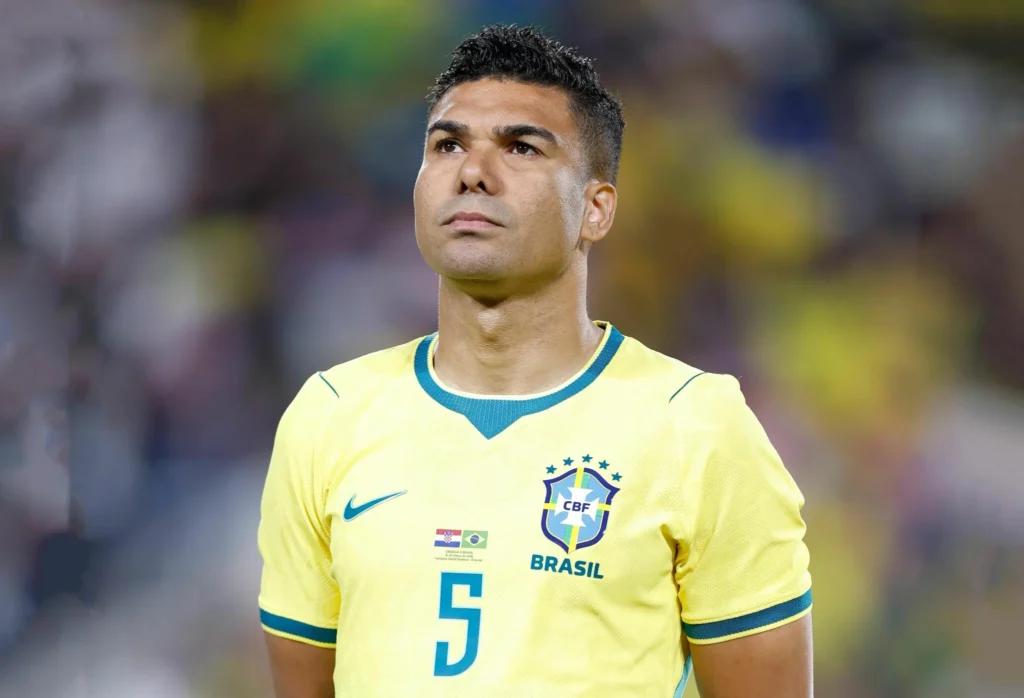 Casemiro com a camisa da Seleção Brasileira antes de partida, em imagem no gramado de estádio de futebol.