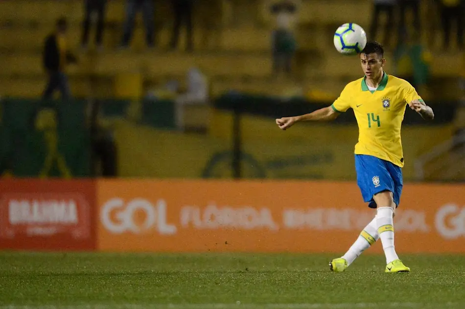 Ibañez domina a bola com a camisa da Seleção Brasileira durante partida em estádio de futebol.