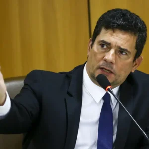 Sergio Moro durante entrevista, gesticulando enquanto fala ao microfone em evento sobre política no Paraná.
