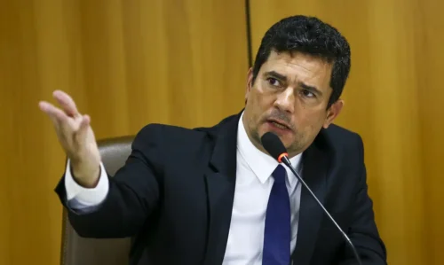Sergio Moro durante entrevista, gesticulando enquanto fala ao microfone em evento sobre política no Paraná.